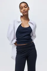 Pantalón de punto de algodón suave, color azul marino, con cintura ancha plegable y piernas rectas con bajo acampanado.