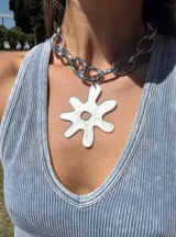 Collar plateado con cadena de eslabones grandes y dije abstracto con forma de flor color negro con glitter. El dije es desmontable.