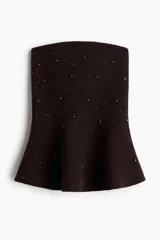 Top strapless de punto color marrón oscuro, con ajuste entallado y peplum acampanado en el ruedo. Presenta cuentas metálicas decorativas distribuidas por toda la prenda y borde interno de silicona en el escote para mayor sujeción.