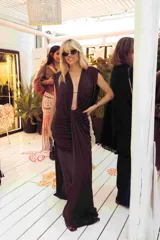 Vestido largo color chocolate con escote profundo en V, diseño sin mangas y detalle de fruncido en la cintura que crea un efecto drapeado en la falda.