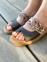 Sandalias bajas de cuero con dos tiras, una de cuero liso color gris y otra con estampado animal print.