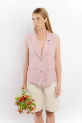 Chaleco color amarillo pastel de lino, sin mangas, con cuello solapa y cierre frontal con dos botones.