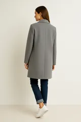 Tapado de corte recto y largo medio, confeccionado en tejido texturizado color gris. Presenta solapas clásicas, cierre frontal de un solo botón y mangas largas.