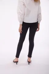 Jean skinny de tiro medio, color azul medio, con bolsillos delanteros y traseros.