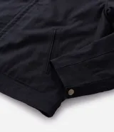 Campera tipo trucker de sarga color azul marino, con cuello de terciopelo al tono, cierre frontal de cremallera y bolsillo con cierre en el pecho.