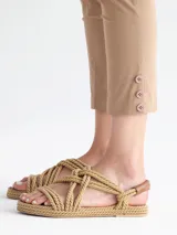 Pantalón capri color beige con detalle de tres botones en el ruedo.