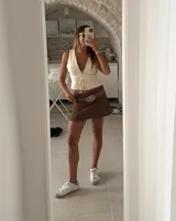 Short pollera blanco de gabardina elastizada, con corte acampanado y cierre frontal con botones.