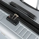 Valija grande plateada de policarbonato, con candado TSA, cuatro ruedas y compartimento interno con cierre.