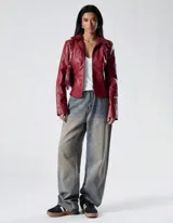 Chaqueta entallada de efecto cuero en color rojo profundo, con cierre frontal, cuello estructurado y acabado levemente brillante.