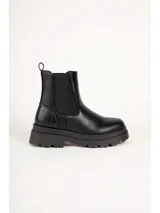 Bota chelsea de cuero color negro, con suela track chunky y detalle texturizado en la parte trasera del talón. Cuenta con paneles elásticos laterales y presilla en la parte superior trasera para facilitar el calce.
