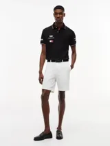 Chomba negra de algodón elástico con cuello polo, cartera de dos botones y mangas cortas. Presenta detalles de ribetes con diseño Global Stripe en el cuello y los puños, además de los logotipos de Tommy Hilfiger, TH x Cadillac Formula 1 Team, Pirelli y el número 11 en las mangas y el pecho.