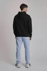 Buzo hoodie azul marino de algodón con corte holgado, capucha con cordones ajustables, bolsillo tipo canguro y etiqueta con logo en el frente.