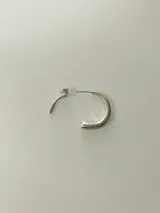Aros de silueta orgánica y diseño continuo en plata, de forma circular con terminación abierta.