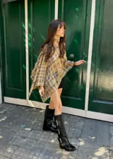 Botas de caña alta confeccionadas en ecocuero negro, con diseño de tres hebillas metálicas laterales y suela plana.