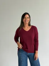 Sweater de punto en color bordó, con escote en V, mangas largas y diseño de corte recto con dobladillo ligeramente más largo en la parte posterior.