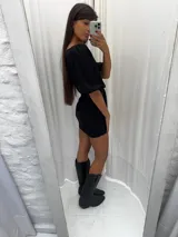 Vestido corto de lino color negro, con mangas globo y lazo ajustable en la cintura. Presenta un diseño entallado con pinzas y falda corta.