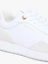 Zapatillas de piel Tommy Hilfiger de corte bajo, color blanco con paneles de ante en tono gris claro, inspiradas en modelos de running retro con suela de EVA y detalles distintivos.