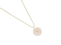Collar de acero con baño de oro, compuesto por una cadena fina y un dije circular de cuarzo rosa natural con una circonia engastada en el centro.
