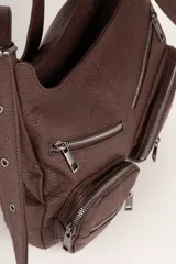 Cartera tipo hobo de cuero sintético negro con textura, cuenta con cuatro bolsillos frontales con cierre, un compartimento principal amplio y asa regulable.