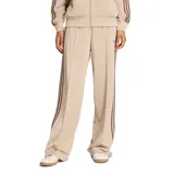 Pantalón deportivo Adidas de corte holgado, color beige con las tres tiras características en los laterales en tono marrón. Presenta diseño de pierna recta, bolsillos laterales y logo de la marca bordado.