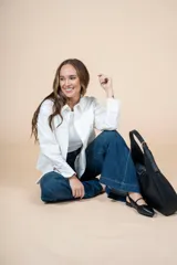 Camisa blanca de corte clásico con bolsillo en el pecho, mangas largas y botones al tono.