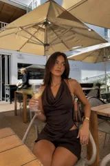 Top marrón de satén con cuello halter drapeado y espalda descubierta.