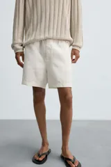 Bermuda relaxed fit confeccionada en tejido ligero de cáñamo. Presenta cintura elástica ajustable con cordón interior, bolsillos laterales y un bolsillo trasero de plastrón con solapa.