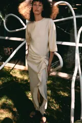 Vestido midi de Zara Woman Collection, confeccionado en mezcla de viscosa, con cuello redondo, manga corta y detalle de drapeado lateral con volado. Presenta bajo asimétrico y cierre en la espalda.
