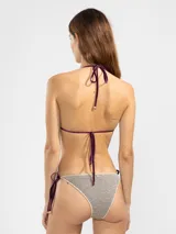 Top de bikini triángulo de lurex brillante color dorado con terminaciones en overlock y tiras ajustables en cuello y espalda.