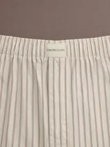 Pantalón de pijama de corte relajado y pernera ancha, confeccionado en popelina de algodón. Presenta cintura elástica con etiqueta de marca y bolsillos laterales.