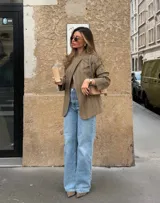 Blazer de corte relajado con diseño cuadrillé en tonos beige y marrón. Presenta hombros levemente estructurados, cierre cruzado con un botón y solapas clásicas.