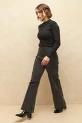 Pantalón de jean negro, ancho, de tiro alto y con dobladillo en las terminaciones.