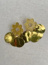 Aros dorados con forma de flor brillante en la parte superior y múltiples discos metálicos colgantes.