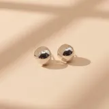 Aros tipo argolla pequeña de diseño esférico y superficie lisa pulida, confeccionados en plata 925.