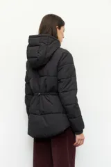 Campera puffer color tostado con capucha, cierre frontal con botones a presión y bolsillos laterales. Presenta diseño acolchado, puños elásticos y ajuste en la cintura.