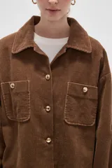Sobrecamisa de pana color verde oliva oscuro, con cuello clásico, cierre frontal con botones metálicos y dos bolsillos delanteros con solapa y botón.