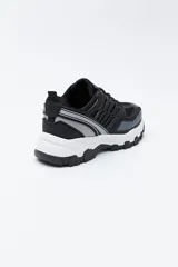 Zapatilla deportiva de estilo trekking con diseño técnico y urbano. Presenta una estructura combinada de paneles de malla y piezas de poliuretano, con sistema de cordones integrado y suela robusta con relieve para mayor estabilidad.