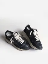 Zapatillas urbanas Golden Goose Running Sole, color negro con detalles en blanco. Confeccionadas en cuero y gamuza, con estrella distintiva en el lateral y suela con efecto desgastado.