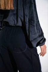 Pantalón de jogging negro de corte holgado, con cintura elástica ajustable mediante cordón y logo pequeño estampado en la pierna derecha.