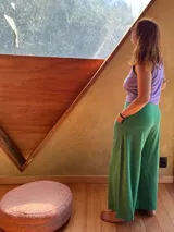 Pantalón tipo palazzo de tiro alto, confeccionado en jersey de algodón color verde. Presenta un diseño amplio con bolsillos laterales y una faja ancha en la cintura que proporciona soporte y ajuste.