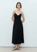 Vestido midi de corte recto y diseño minimalista, confeccionado en una mezcla de viscosa y poliamida. Presenta escote en pico con detalle de lazo frontal y tirantes finos ajustables.