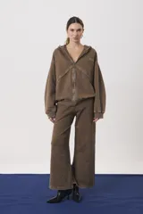 Campera con capucha y cierre frontal, confeccionada en tejido de punto con efecto lavado. Presenta mangas largas con puños ajustados y un corte relajado.