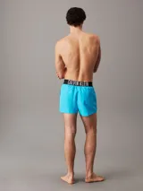 Short de baño celeste con cintura elástica negra y logo de Calvin Klein en blanco.