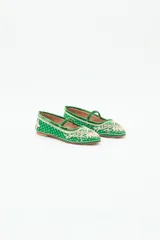 Bailarina negra de estilo plano con tira de terciopelo que cruza el empeine. Presenta bordados intrincados en hilo dorado y apliques de lentejuelas y cuentas en la punta y el cuerpo del zapato.