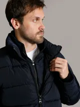 Campera puffer azul marino de Calvin Klein, de diseño acolchado con cuello alto y cierre frontal de cremallera. Incluye bolsillos laterales con cierre y chaleco interior desmontable.