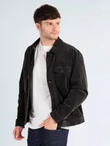 Campera de pana color gris oscuro, con cierre frontal de botones, cuello clásico y bolsillos frontales con solapa y botón.