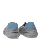 Championes tipo mocasín slip-on Merrell Hut Moc 2, color gris con diseño acolchado tipo matelassé. Presenta talón colapsable, suela de EVA ligera y detalles en azul en la parte posterior.