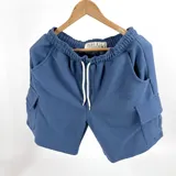Bermuda azul de algodón fino con textura waffle, corte recto, cintura elastizada con cordón ajustable, bolsillos laterales y bolsillos cargo con solapa en los laterales.