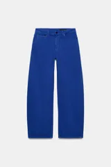 Jeans de tiro medio y corte barrel leg, de color azul, con diseño de cinco bolsillos y trabillas en la cintura. Cierre frontal con cremallera y botón metálico.