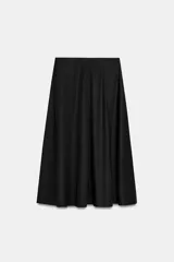 Falda midi negra de tiro alto, corte en A y diseño fluido con bolsillos laterales ocultos.